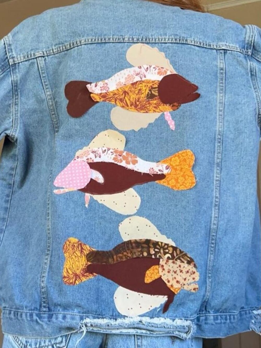 Blue denim jacket with three fish appliqués